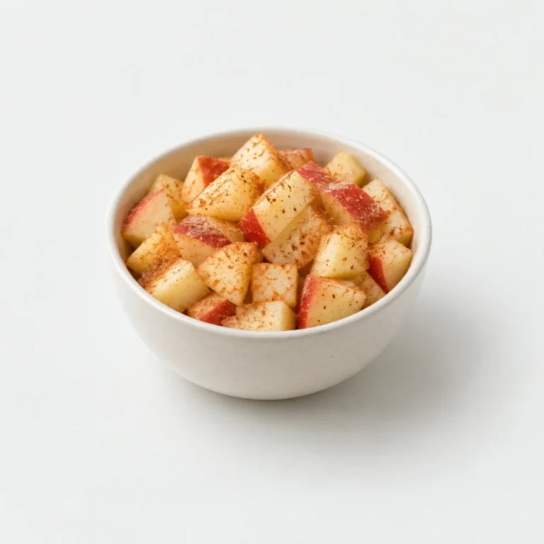 Diced apple pieces with cinnamon in a plain bowl